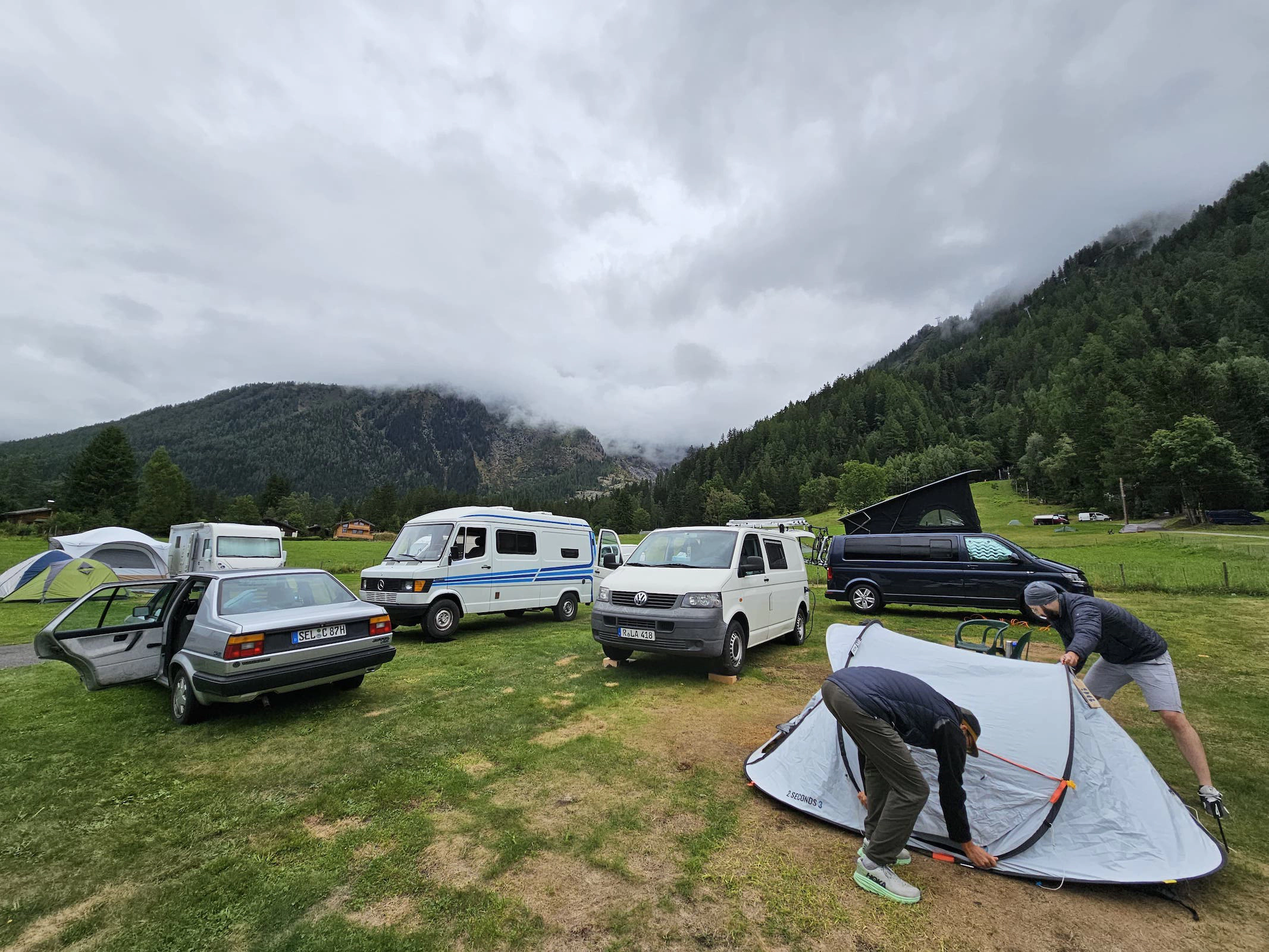 Zelte und Wohnmobile auf einem Campingplatz in den Bergen