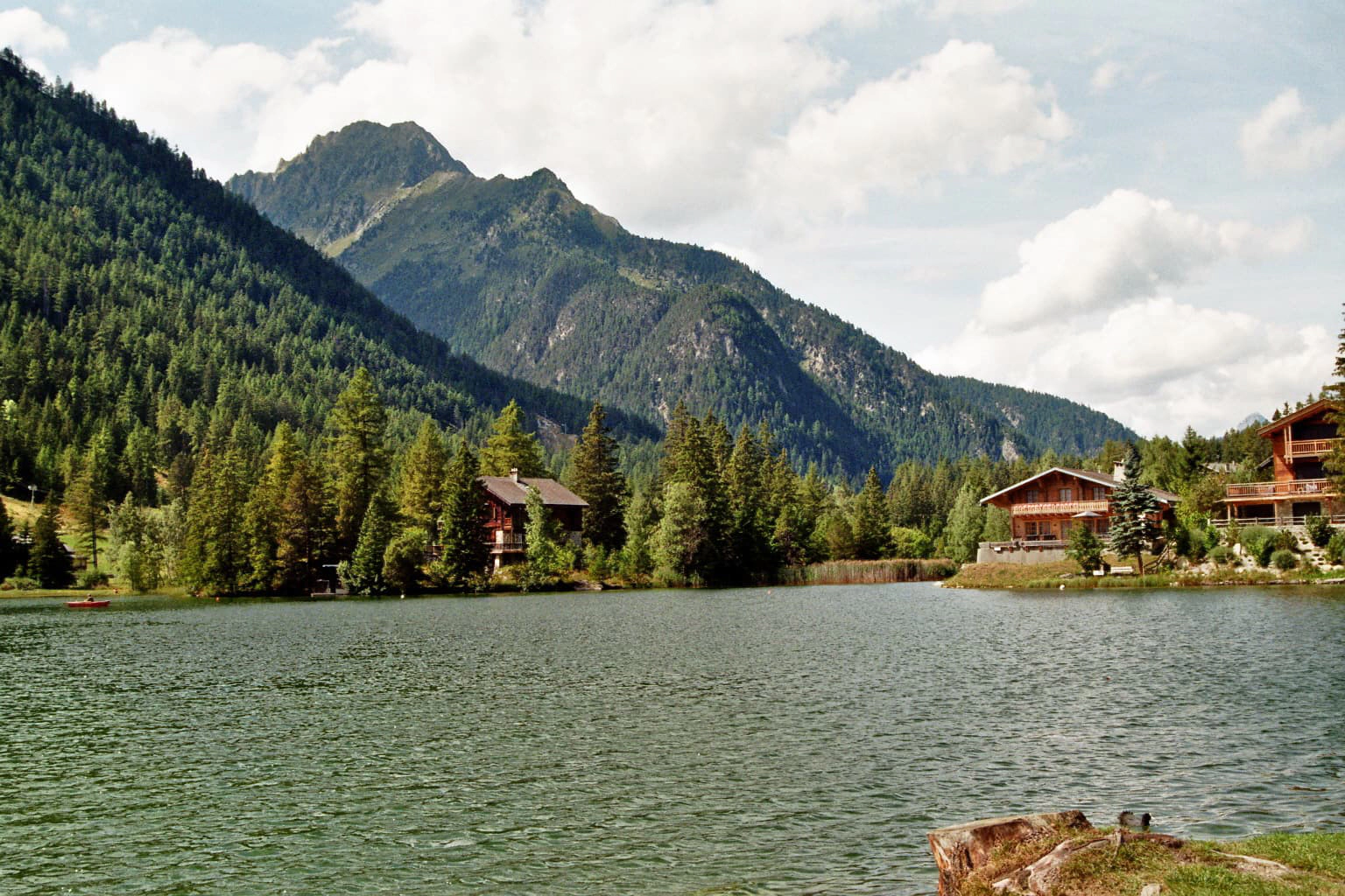 Der Bergsee in Champex Lac mit blauem Himmel, klarem Wasser und Bergen im Hintergrund.