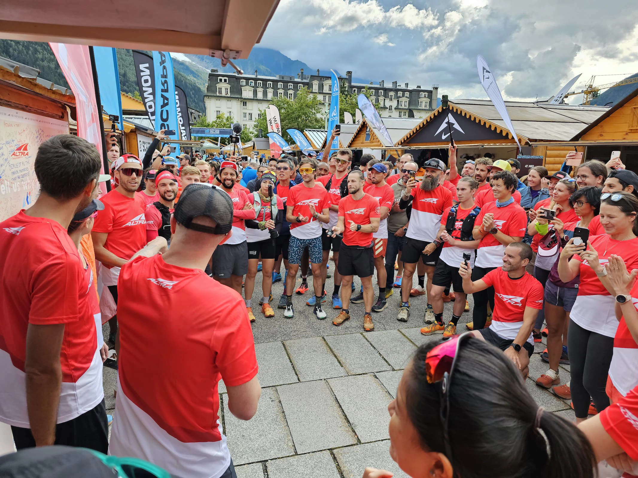 Eine große Gruppe Athleten im gleichen roten Shirt macht sich bereit gemeinsam los zu laufen.